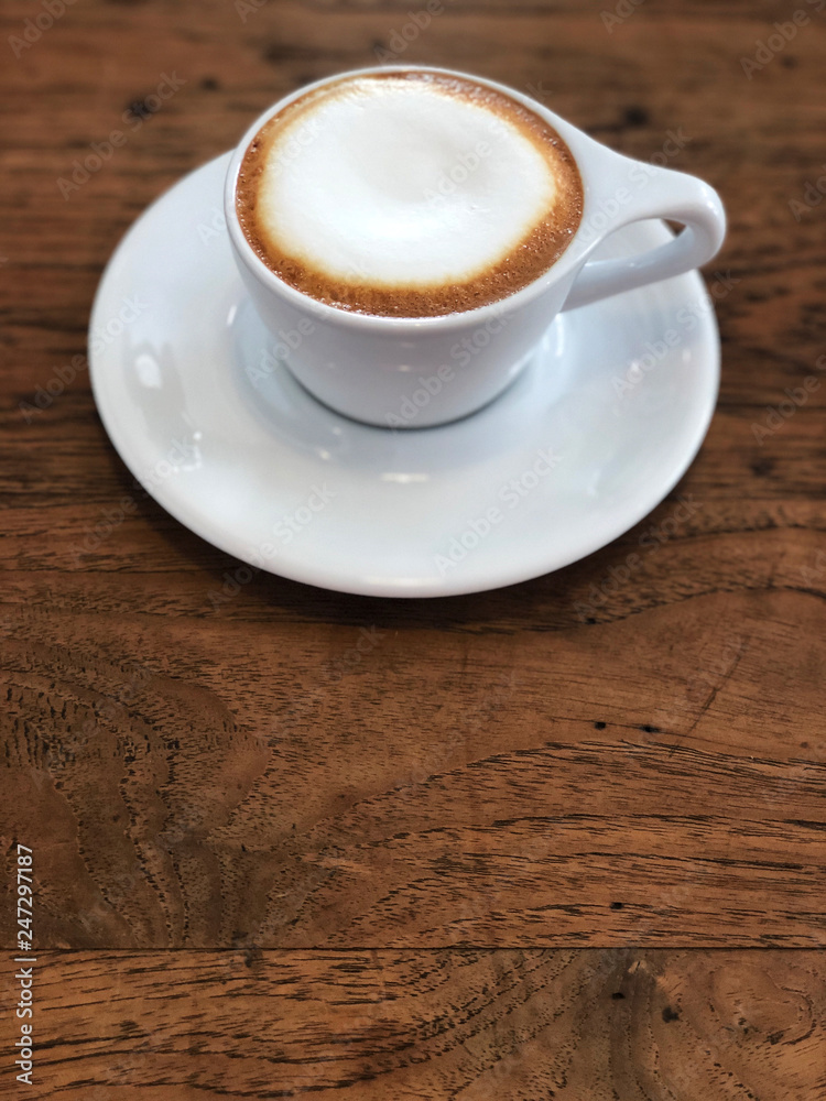 Cappuccino coffee in white cup on the wooden table. Relaxing and fulfill energy. Copy space Cappuccino coffee in white cup on the wooden table. Relaxing and fulfill energy. Copy space