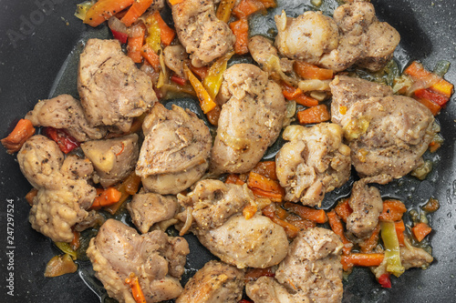 Fotografía Top view on a pan with turkey meat pieces fried in sunflower-seed oil and vegeta