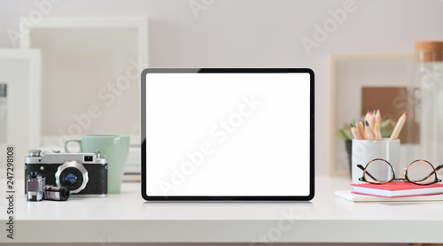 Mockup blank screen tablet on wood desk with vintage camera and creative supplies