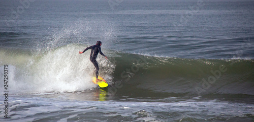 Surfer on wave at sandbar where the Santa Clara River empties into the Pacific Ocean at McGrath State Park in Ventura California United States