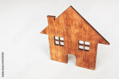 A little flat wooden house isolated on the white table and space for your text or design