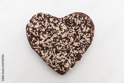 Chocolate heart-shaped topping with granulated chocolate. Celebration for Valentine s Day or Mother s Day. Isolated on white background. Top view. Close-up.