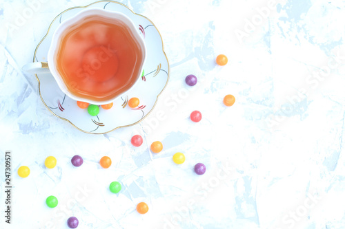 Cup of tea with sweets on a light background.