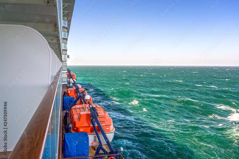 Obraz premium Cruise line ship side with lifeboats and balcony stateroom.