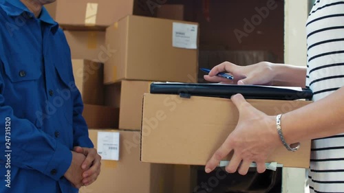 Close up of courier giving box to addressee and waiting for him signing up document
