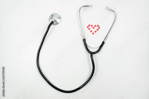 Medical background with with statoscope and pills. Сoncept pharmacy, clinic, drugs, headache medicine. Image on illness, cardiology, treatment