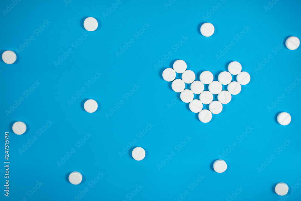 Medical background with multi-colored packs of pills. Сoncept pharmacy, clinic, drugs, headache medicine. Image on illness, flu, treatment. White heart shaped pills