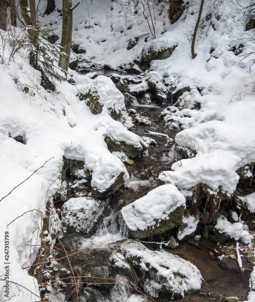mountain sreeam with stones, small rapiids and snow during winter mountain sreeam with stones, small rapiids and snow during winter