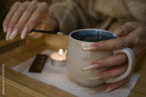 Woman hands with long nails holding a cup on tea ceremony