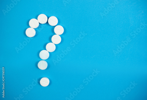 Medical background with multi-colored packs of pills. Сoncept pharmacy, clinic, drugs, headache medicine. Image on illness, flu, treatment. White question mark from pills