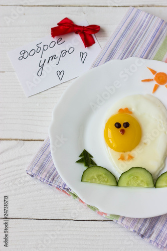 Creative idea for kid breakfast – chick from scrambled eggs and vegetables, inscription «Добро утро»  on a white background free space for text