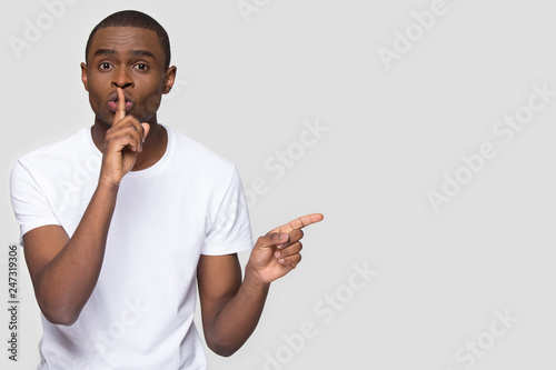 Fényképezés African american man holding finger on lip mouth keep it quiet hush secret point