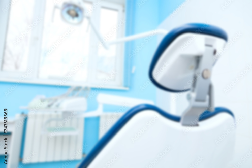 Blurred image of dental office with chair and led lamp. Dental hygiene and healthcare concept. Blurred image of dental office with chair and led lamp. Dental hygiene and healthcare concept.