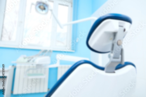 Blurred image of dental office with chair and led lamp. Dental hygiene and healthcare concept.