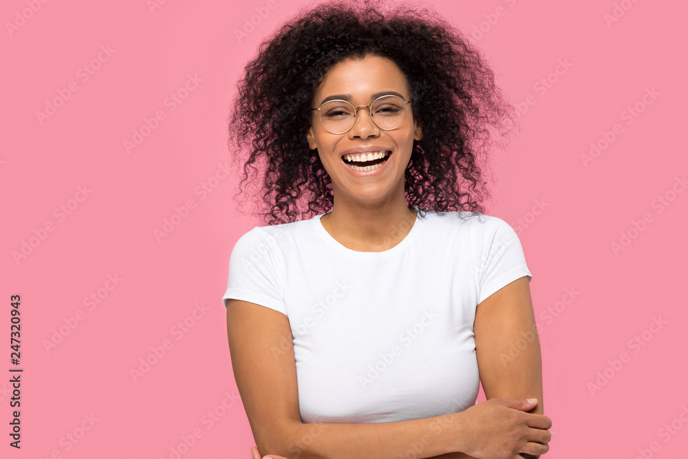 Portrait of happy joyful black woman wearing glasses laughing isolated on pink studio background, cheerful funny african american lady with smile on face enjoy laughter having fun looking at camera
