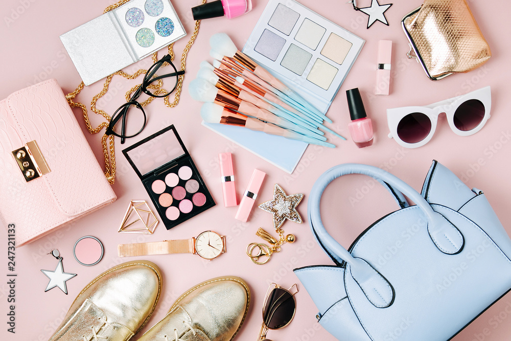 Flat lay of female fashion accessories, makeup products and
