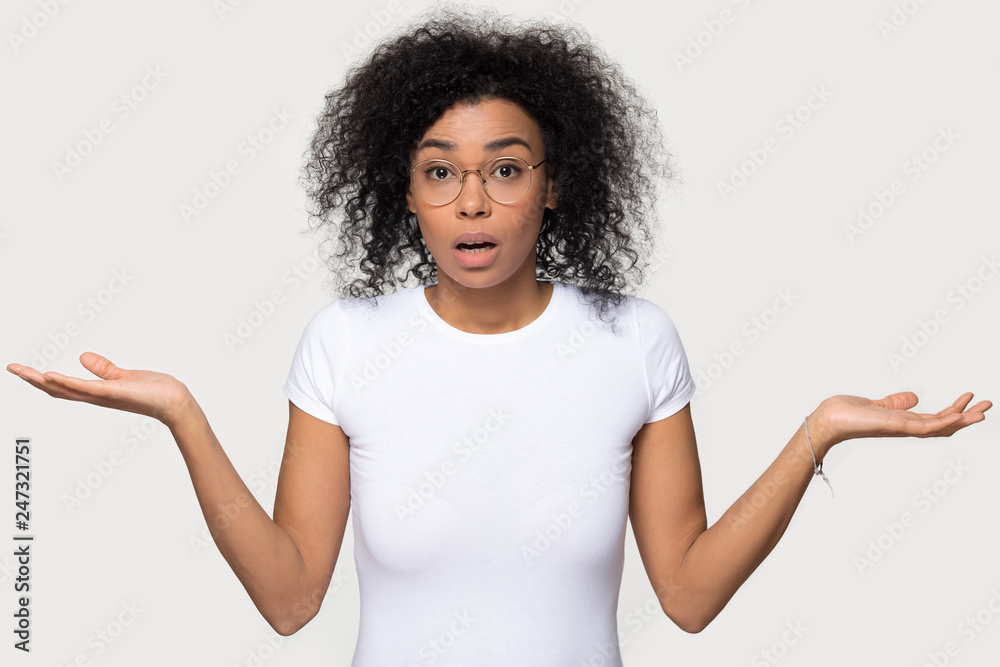Confused doubtful shocked black woman shrugging feel baffled looking at