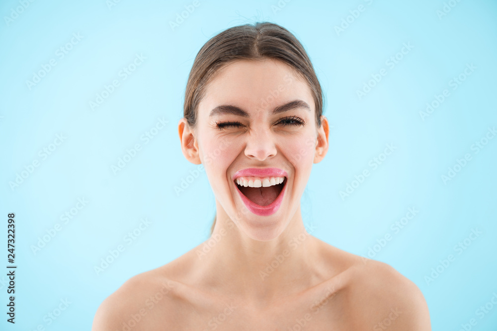 Beautiful happy cheerful young pretty woman posing isolated over blue wall background. Beautiful happy cheerful young pretty woman posing isolated over blue wall background.