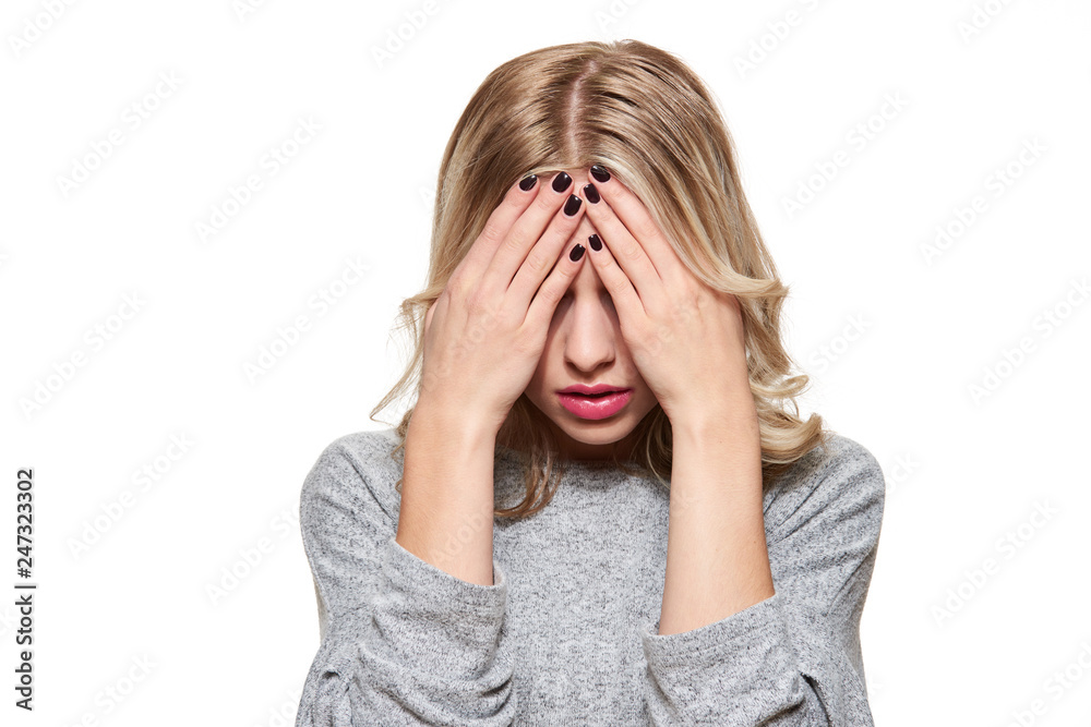 Stressed Exhausted Young Female Student Having Strong Tension Headache. Feeling Pressure And Stress. Depressed Student With Head in Hands Over White Background. Stressed Exhausted Young Female Student Having Strong Tension Headache. Feeling Pressure And Stress. Depressed Student With Head in Hands Over White Background.