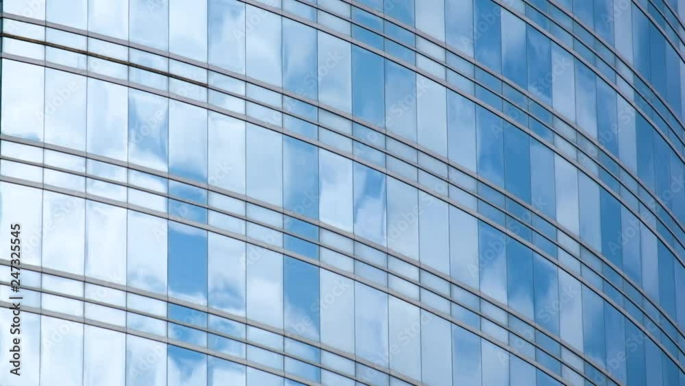 Blue sky and clouds reflected in structural  modular glass wall time lapse