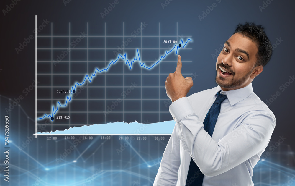 business, success and statistics concept - smiling indian businessman in shirt with tie pointing finger at chart on virtual screen projection over blue background business, success and statistics concept - smiling indian businessman in shirt with tie pointing finger at chart on virtual screen projection over blue background