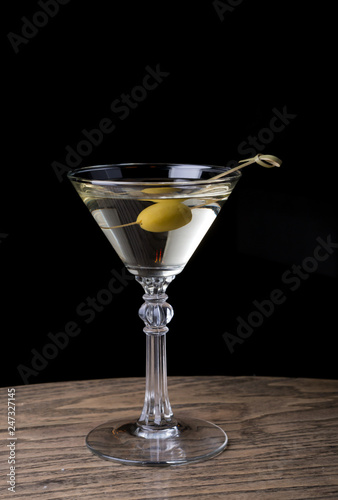 Martini glass with olive on a counter