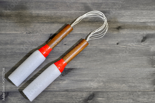 A pair of wooden nunchucks in foam insulation for pipes.