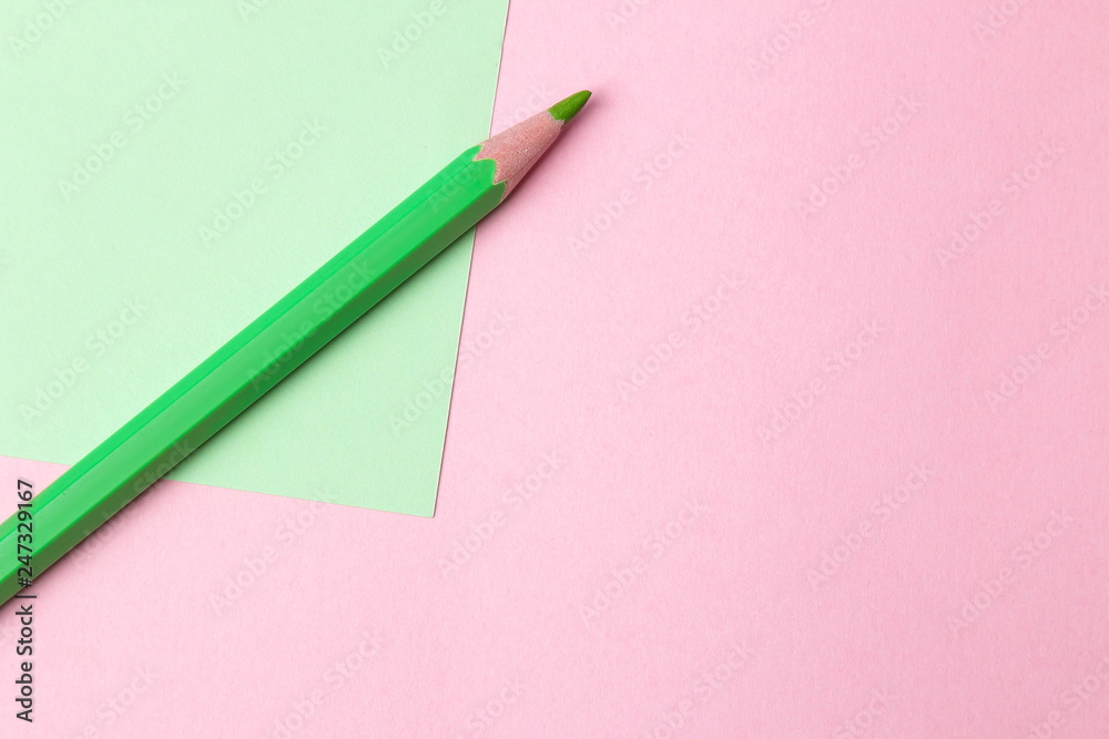 composition with green pencil on a pink and green background. top view. space for text composition with green pencil on a pink and green background. top view. space for text
