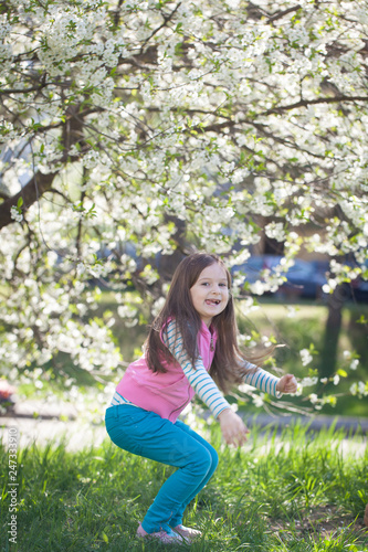 Cute girl in a blooming cherry tree garden