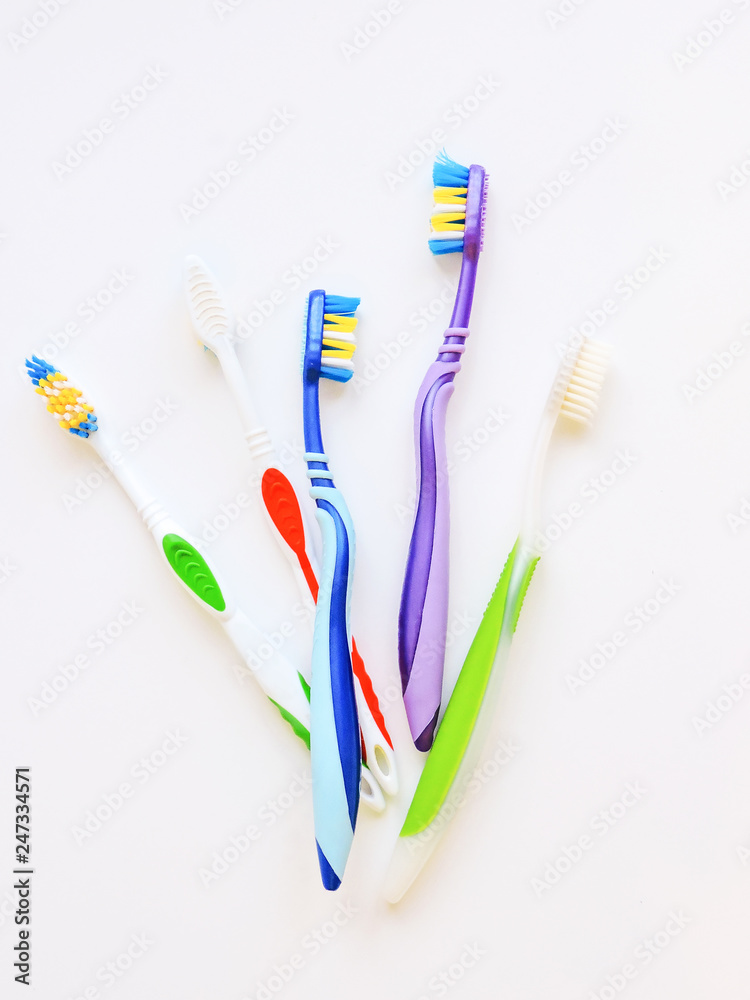 Flat lay composition with manual toothbrushes on white background.Toothbrush and toothpaste.op view, flat lay. Minimal concept, space for text.set of multicolored toothbrushes on white. Flat lay composition with manual toothbrushes on white background.Toothbrush and toothpaste.op view, flat lay. Minimal concept, space for text.set of multicolored toothbrushes on white.