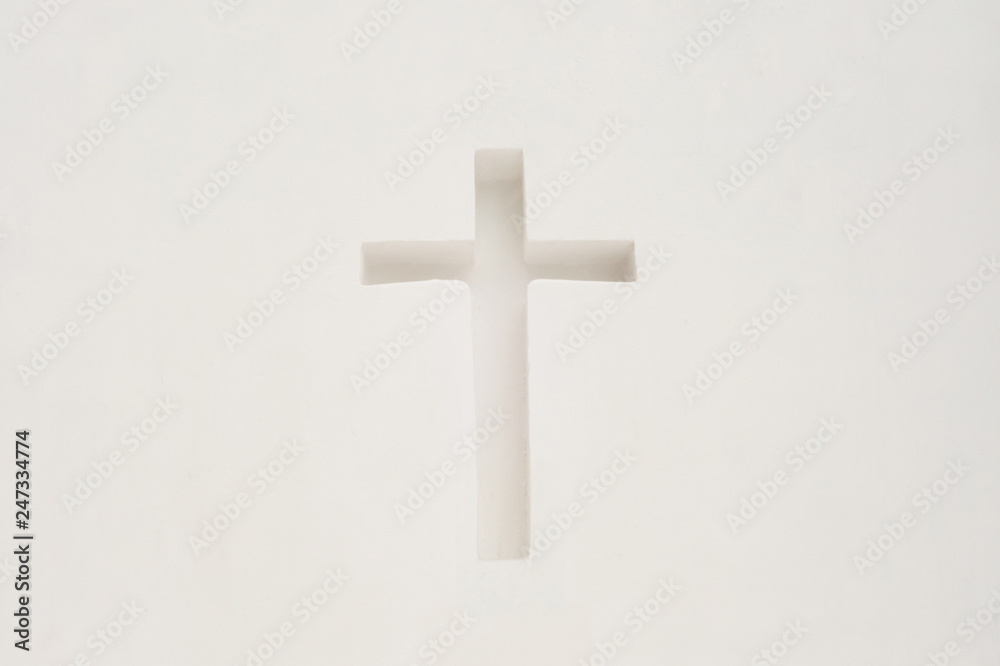 Cross in a white wall. Religious symbol