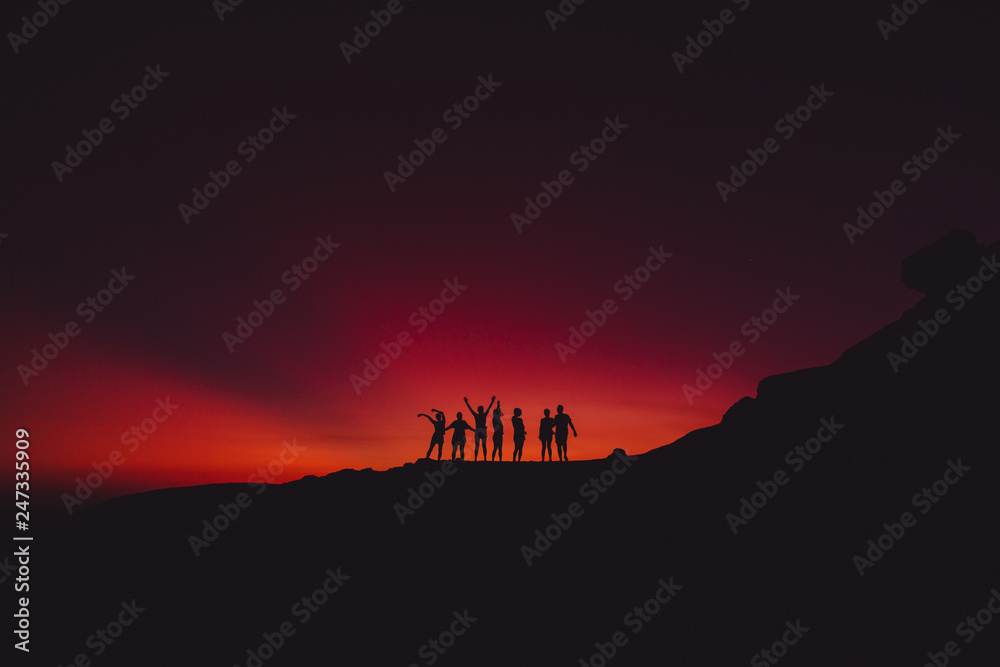 Bright sunset and silhouette of happy people