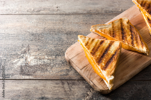 Grilled cheese sandwich on wooden table. Copyspace