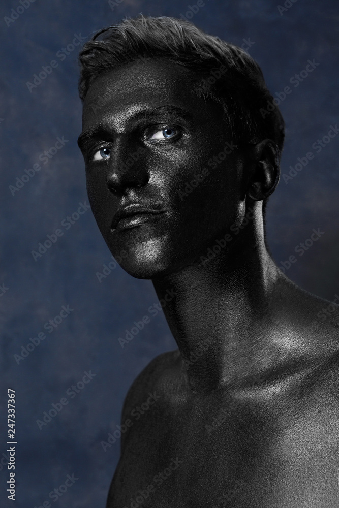 a man in black make-up. portrait in dark paint. Art photography portrait a man in black make-up. portrait in dark paint. Art photography portrait