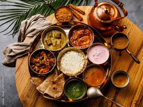 Indian food Thali  Indian-style meal with chicken meat and Masala tea Chai on wooden table photo