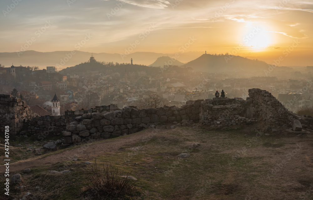 2 girls is watching sunset from ancient fortress wall in Plovdiv city, Bulgaria