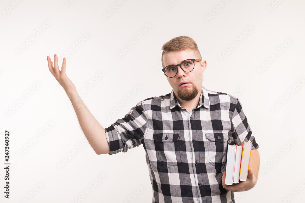 Education, emotions, geek and nerd concept - man in glasses and books looks like he is perplexed Education, emotions, geek and nerd concept - man in glasses and books looks like he is perplexed