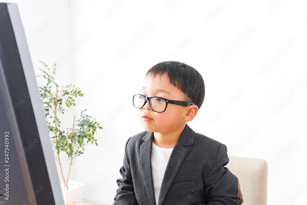 スーツを着て仕事をする子供ビジネスマン