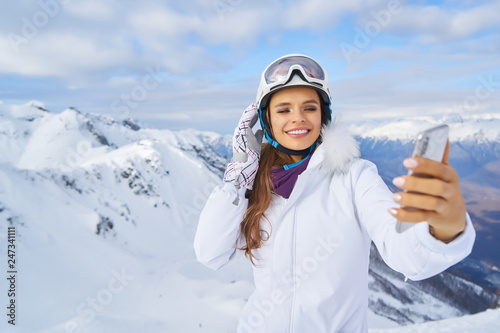  beautiful woman with smartphone on the top of the mountain