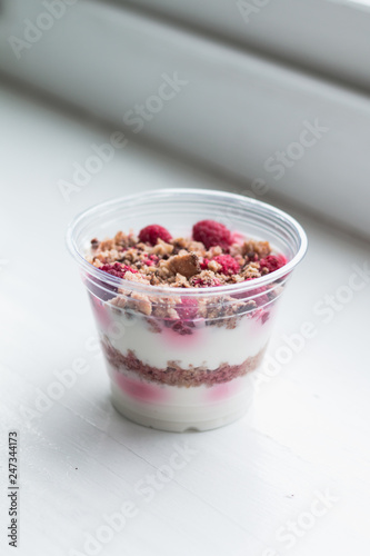 Healthy dessert with raspberries in plastic cup