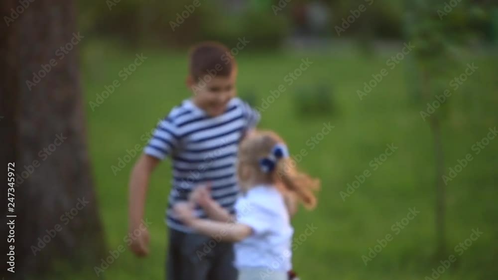 Little boy and girl run and play. They blow dandelion. sunset Little boy and girl run and play. They blow dandelion. sunset