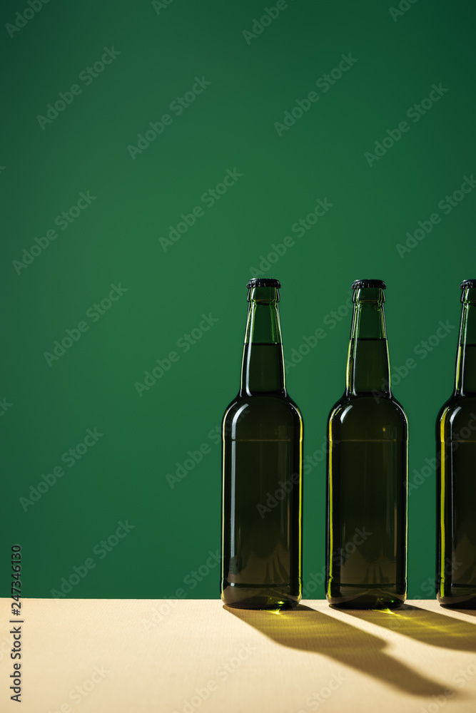beer bottles with shadows and copy space isolated on green, st patrick day concept beer bottles with shadows and copy space isolated on green, st patrick day concept