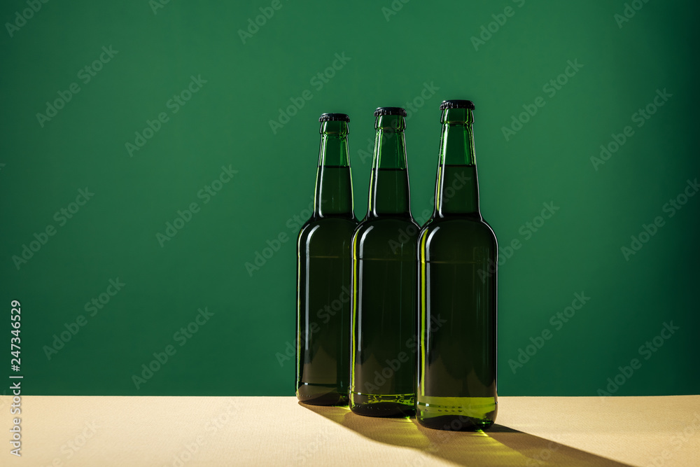 beer bottles with shadows and copy space isolated on green, st patrick day concept beer bottles with shadows and copy space isolated on green, st patrick day concept