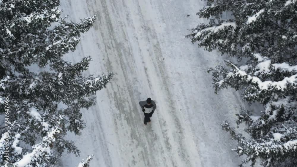 Male runner jogging outdoors in snowy forest. Winter Sport, fitness motivation. Wellness workout in cold weather. Training and exercising. Fresh air lifestyle, inspirational concept Male runner jogging outdoors in snowy forest. Winter Sport, fitness motivation. Wellness workout in cold weather. Training and exercising. Fresh air lifestyle, inspirational concept