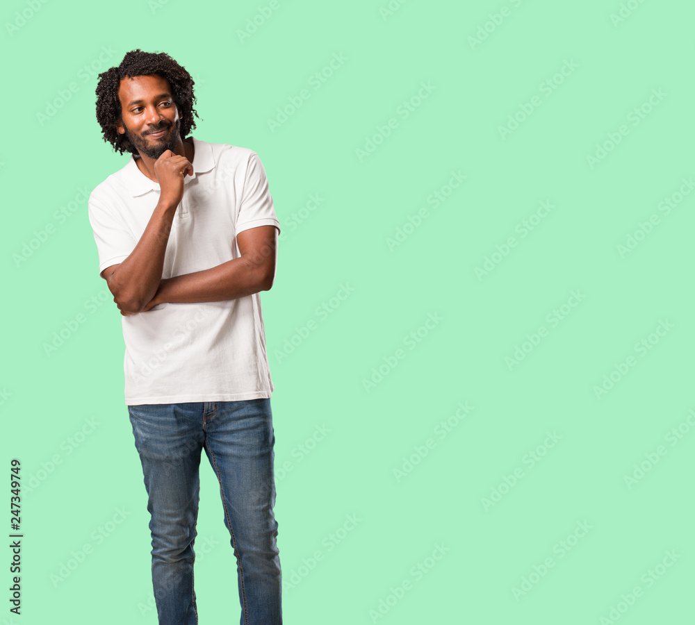 Handsome african american thinking and looking up, confused about an idea, would be trying to find a solution Handsome african american thinking and looking up, confused about an idea, would be trying to find a solution