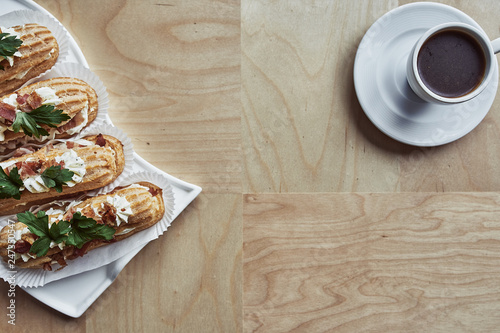 Tasty eclairs on wooden table, close up