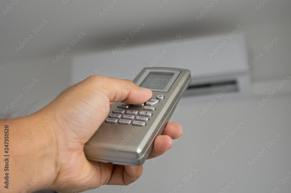 Remote control of air conditioner in human hand. Remote control of air conditioner in human hand.