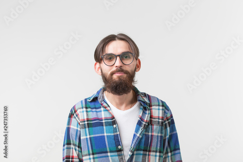 Portrait of a young bearded hipster stylish guy over white background.