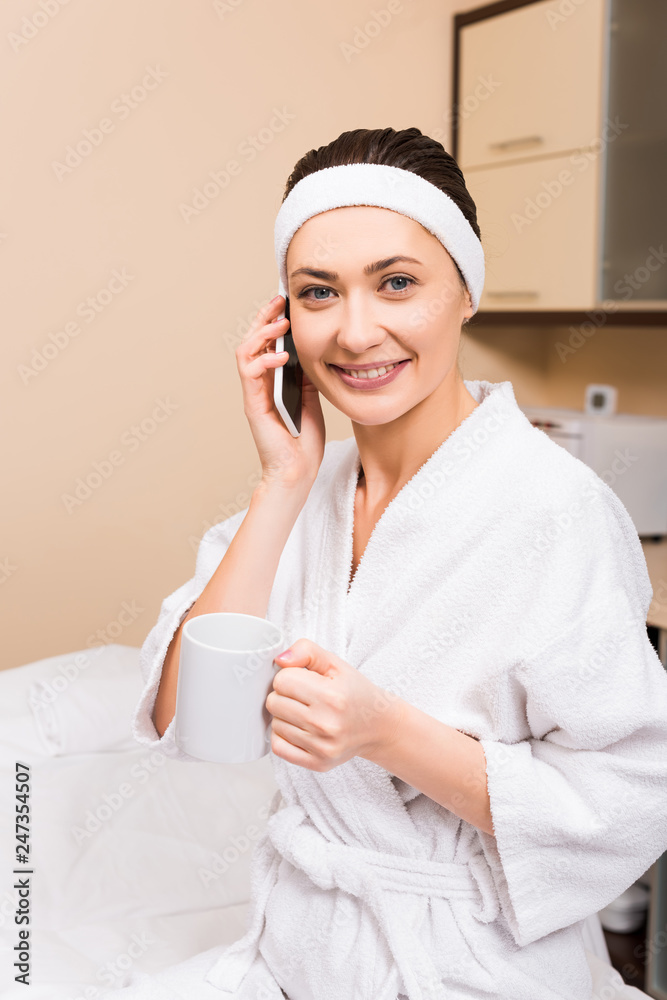 woman holding cup in hand, talking on smartphone and sitting at beauty salon woman holding cup in hand, talking on smartphone and sitting at beauty salon