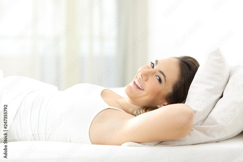 Lady lying on a comfortable mattress looks at you Lady lying on a comfortable mattress looks at you